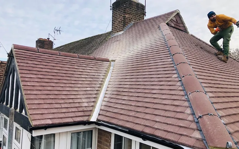 JFC roofer working on a tiled roof next to the chimney
